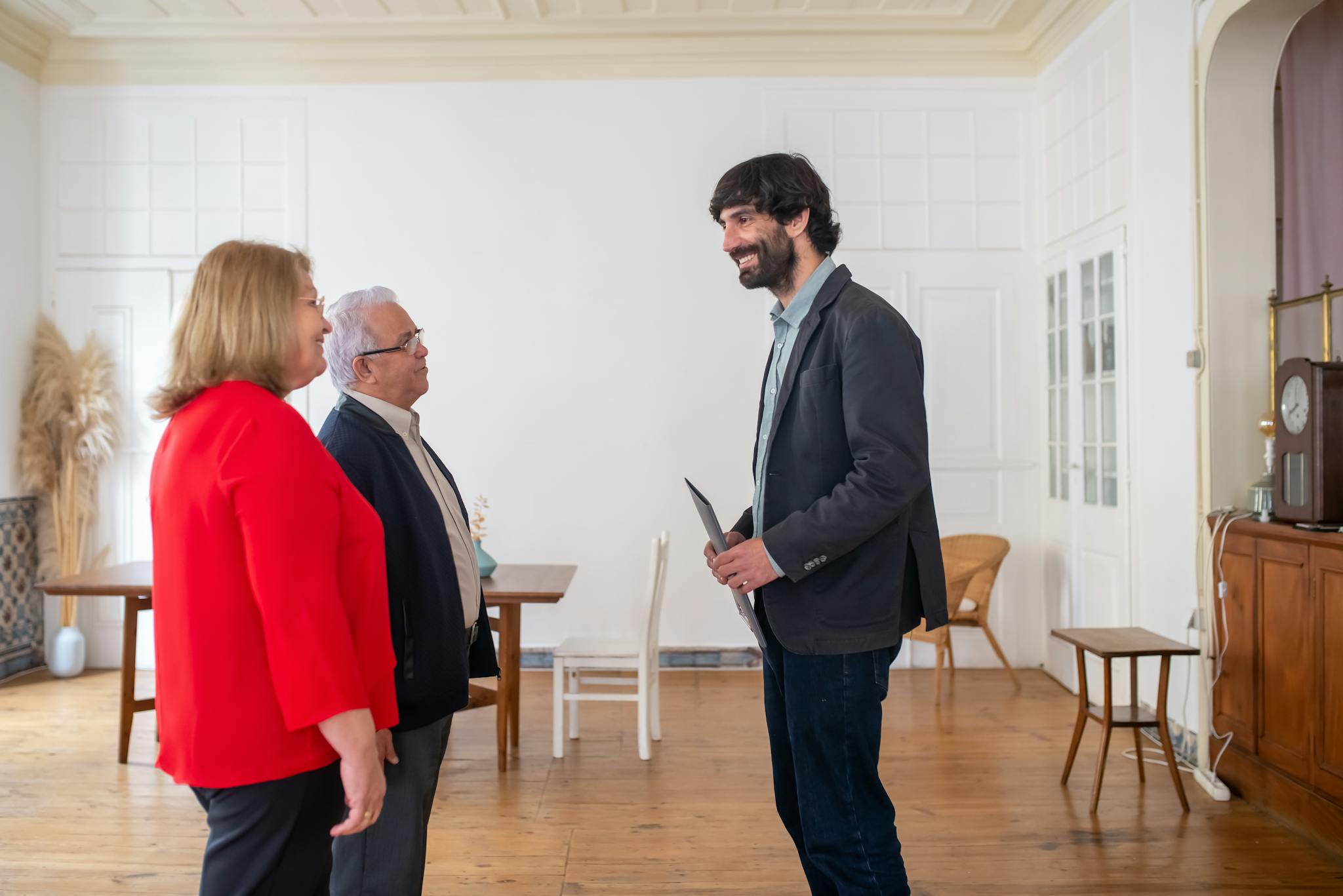 Three adults discussing business in a bright, modern office space.